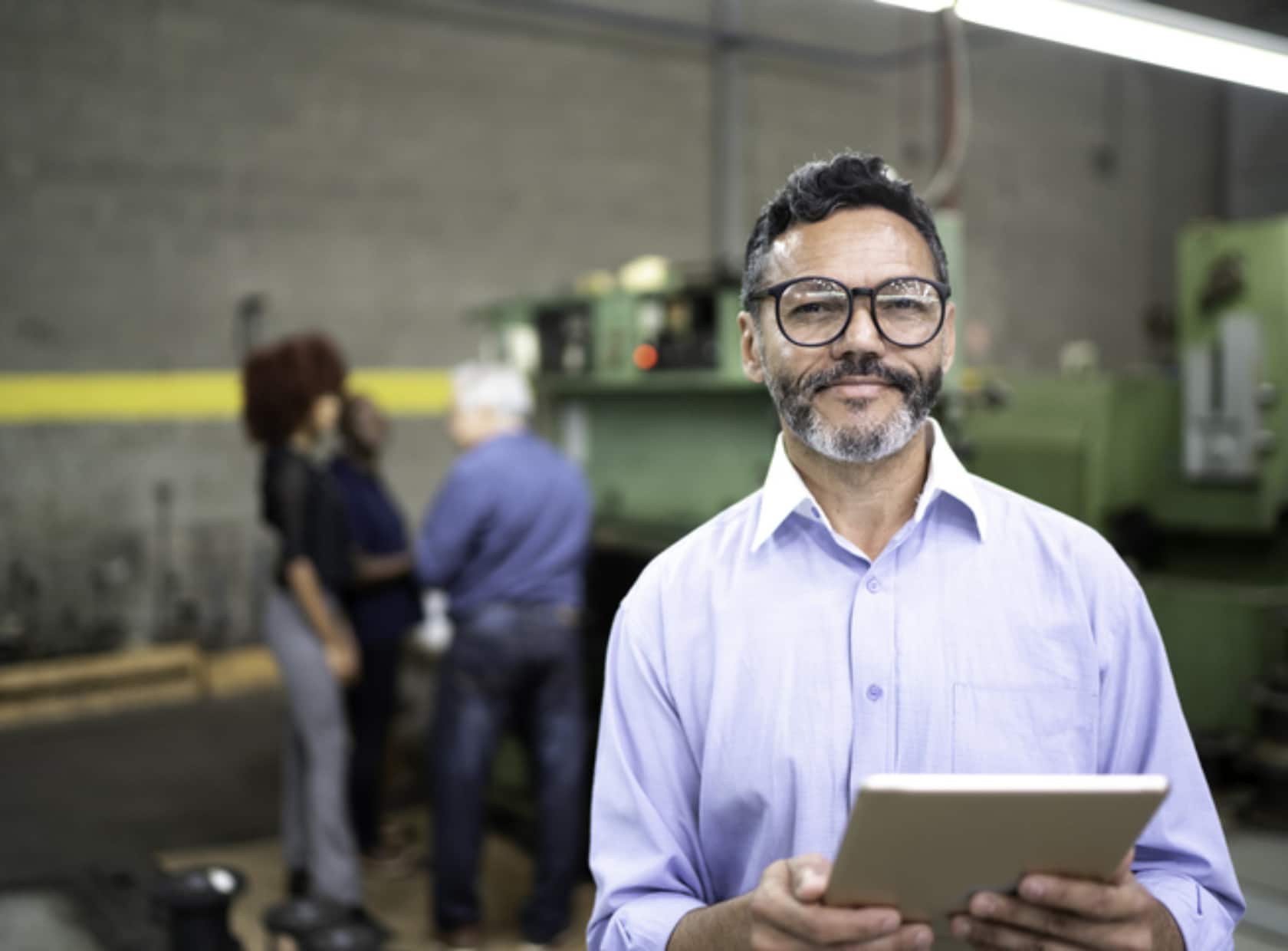 Portrait of a businessman using a digital tablet in the production line of a factory