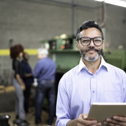 Portrait of a businessman using a digital tablet in the production line of a factory