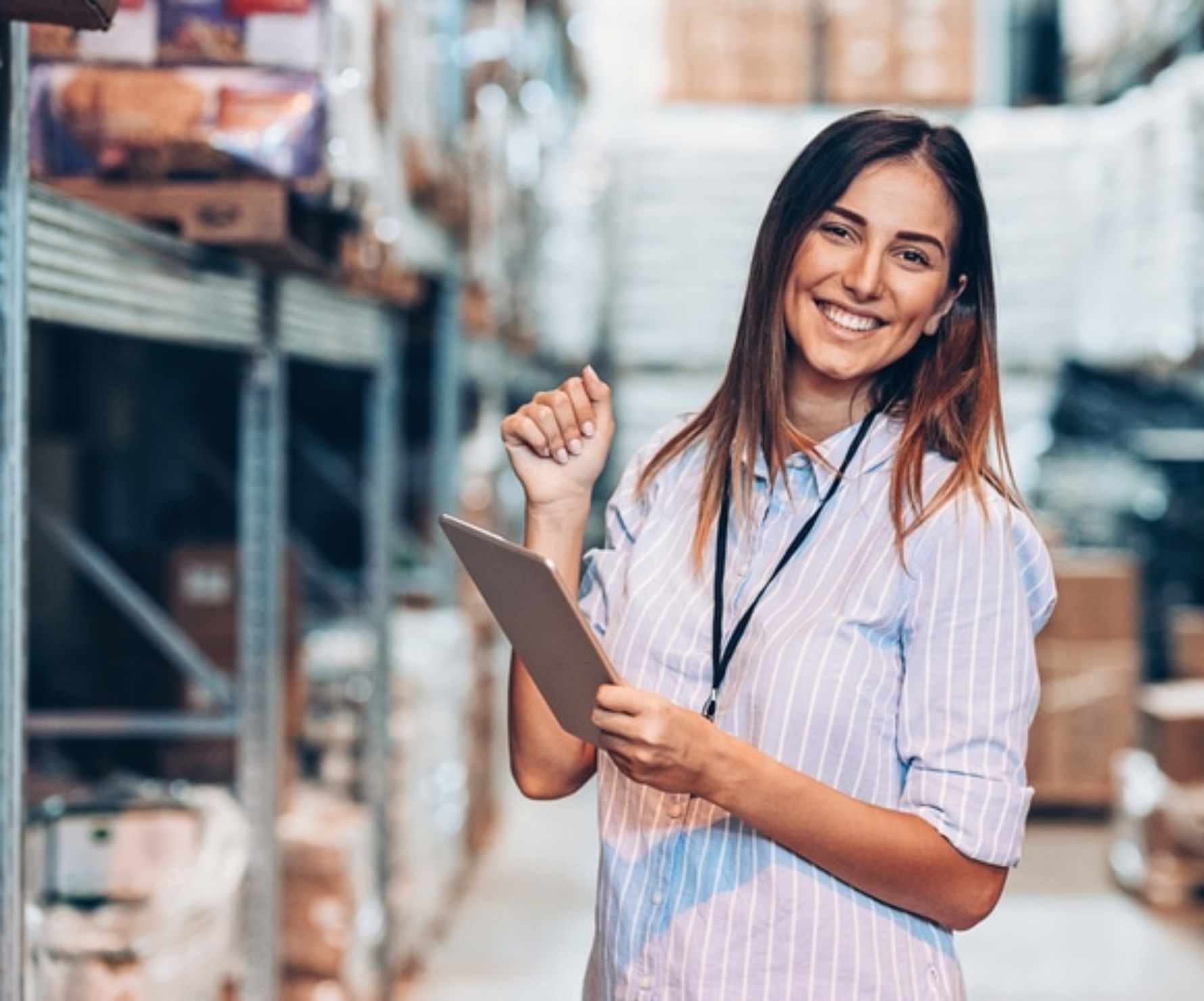 Smiling woman holding a digital tablet in a warehouse
