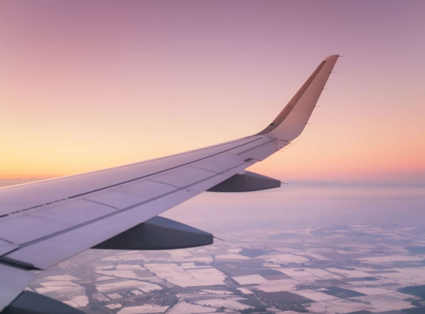 Aircraft wing on the sunrise sky background.