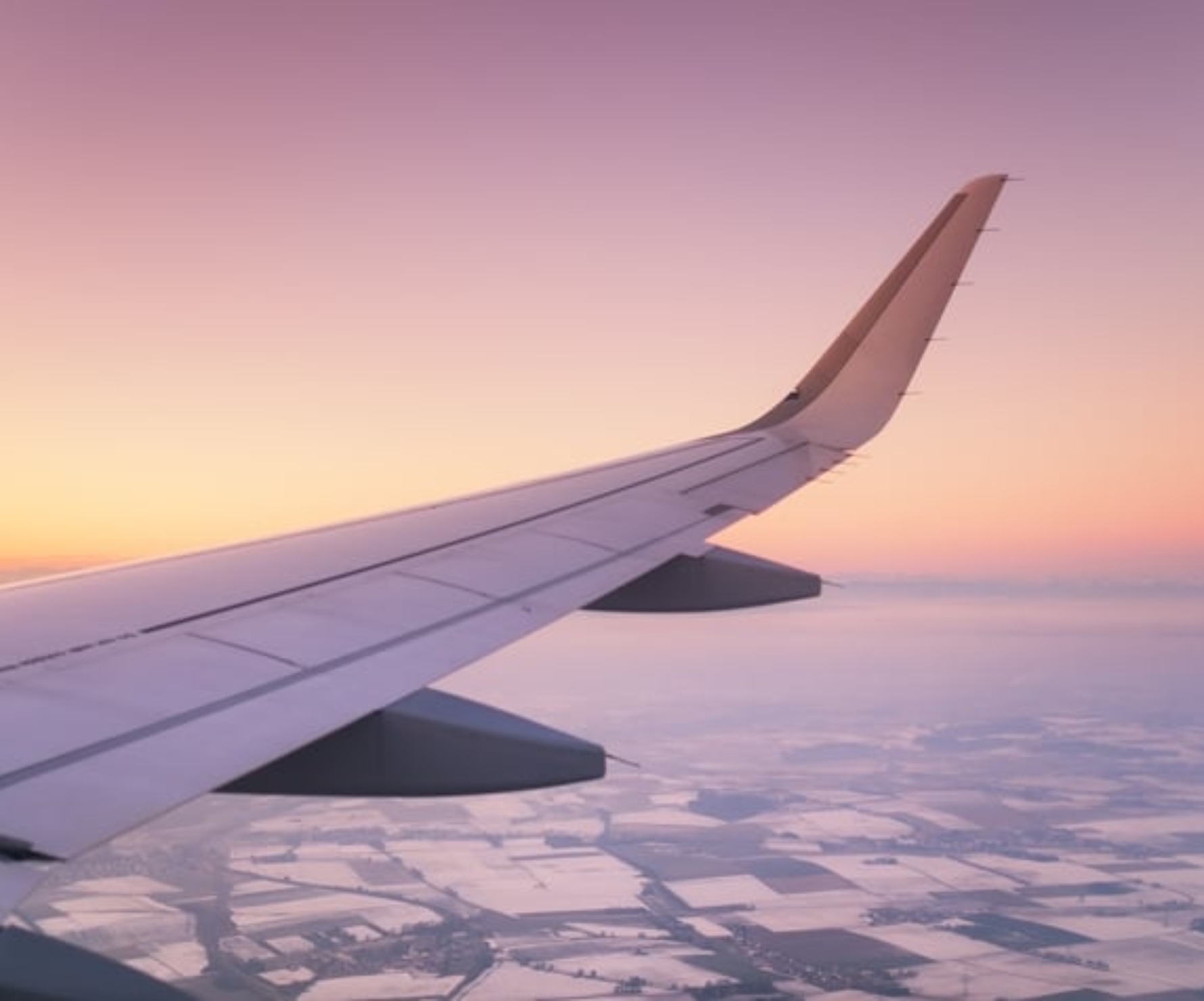 Aircraft wing on the sunrise sky background.