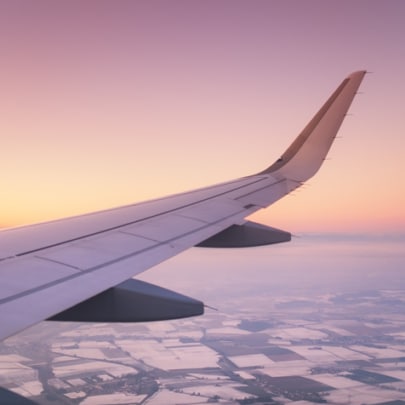 Aircraft wing on the sunrise sky background.