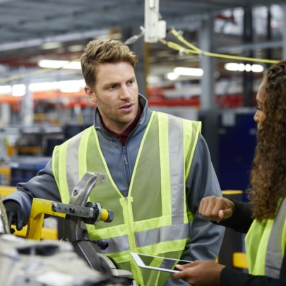 Multi-ethnic engineers discussing over car chassis