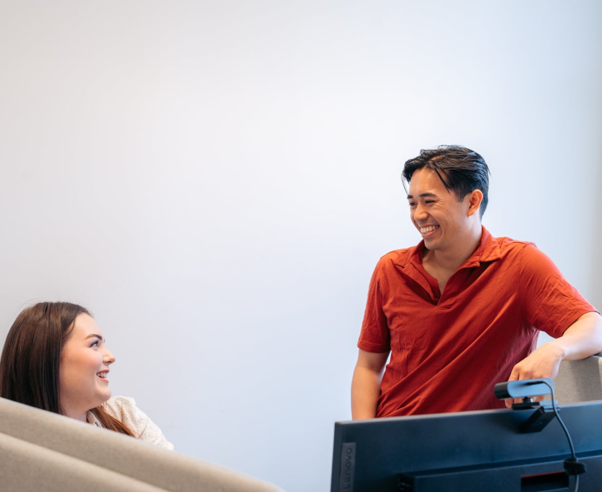 Kvinnelige og mannlige kontoransatte ser på hverandre og ler