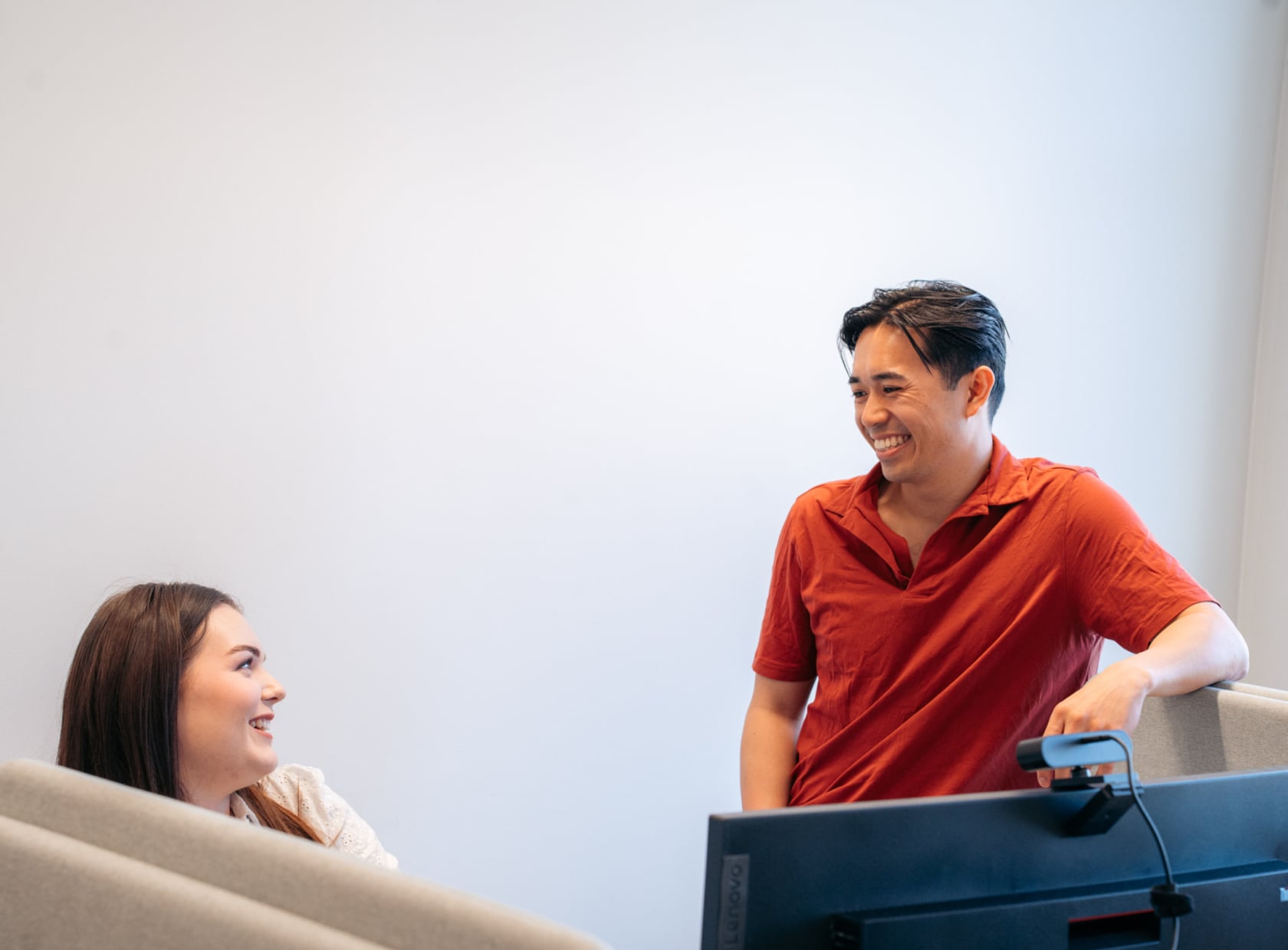 Female and male office employees looking at each other and lauching