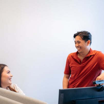 Kvinnelige og mannlige kontoransatte ser på hverandre og ler